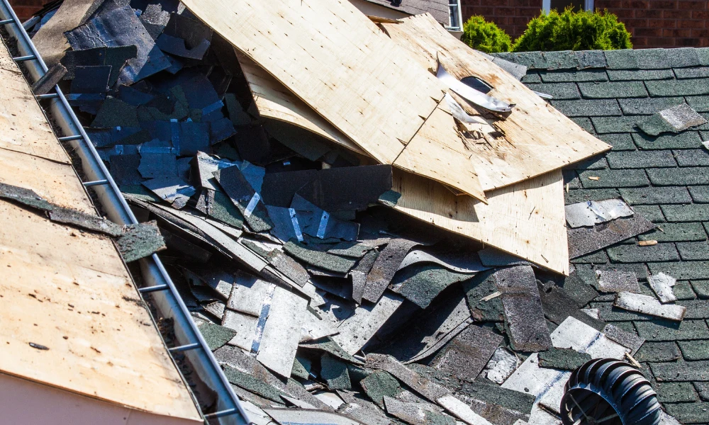 An image showing asphalt shingles being removed from a roof for a replacement.
